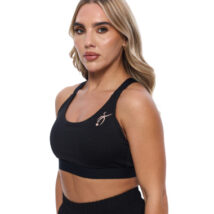 Blonde Female wearing black vest standing in front of a white background