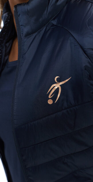 close up of blonde female in blue gilet on white background