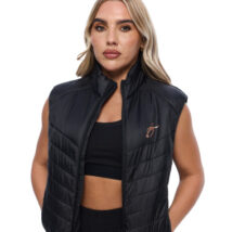 Blonde Female wearing black gilet standing in front of a white background