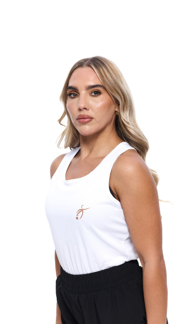 Blonde Female wearing White vest black shorts standing in front of a white background