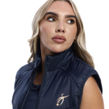 close up of blonde female in blue gilet on white background