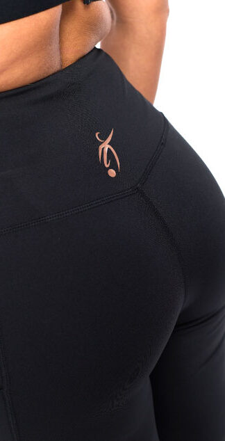 Female wearing black leggings standing in front of a white background