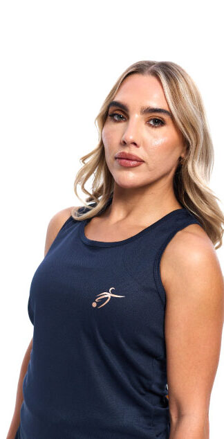 Blonde Female wearing Navy blue vest black shorts standing in front of a white background