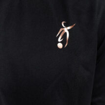 Close up of Male wearing black training top standing in front of a white background