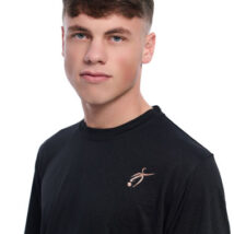 Close up of Male wearing black training top standing in front of a white background