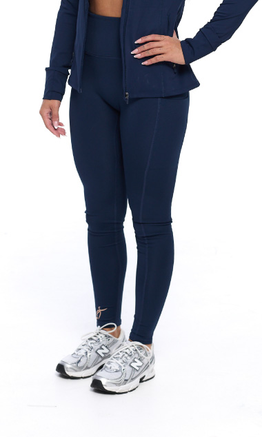 Female wearing Midnight navy leggings standing in front of a white background