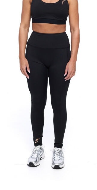 Female wearing black leggings standing in front of a white background