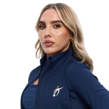 Blonde Female wearing blue tracksuit top standing in front of a white background