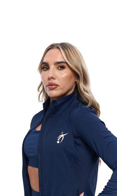 Blonde Female wearing blue tracksuit top standing in front of a white background
