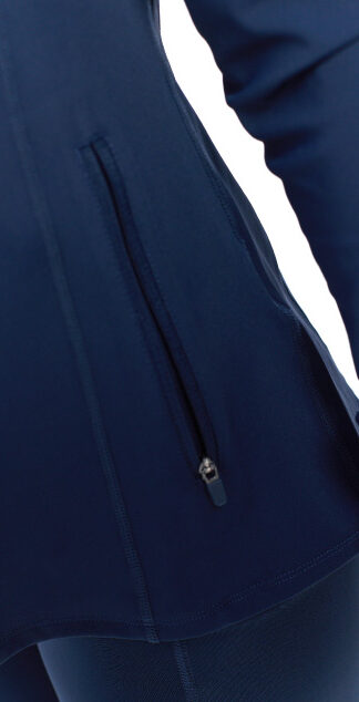 Blonde Female wearing blue tracksuit top standing in front of a white background