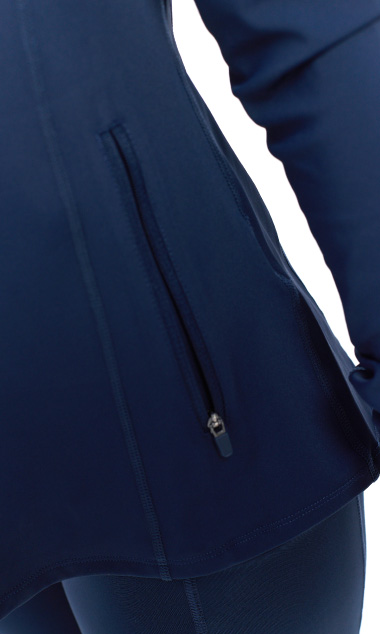 Blonde Female wearing blue tracksuit top standing in front of a white background