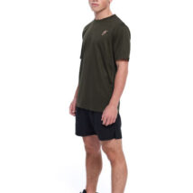 Male wearing green training top and black shorts standing in front of a white background