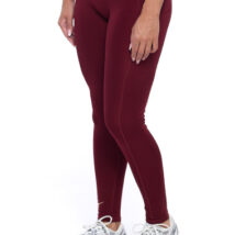 Female wearing Burgandy leggings standing in front of a white background