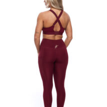 Female wearing Burgandy leggings standing in front of a white background
