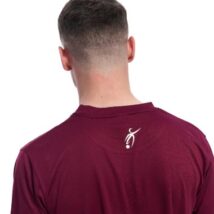 Reverse picture of Male wearing red training top standing in front of a white background