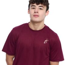 Male wearing Burgandy training top standing in front of a white background